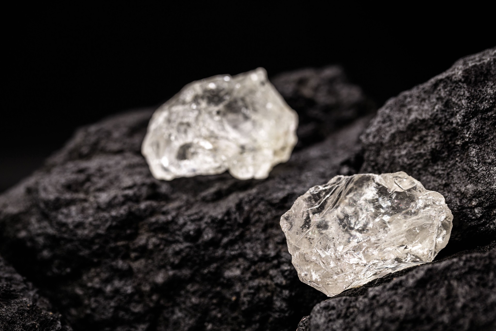 Rohdiamant auf isoliertem schwarzem Hintergrund, seltenes und kostbares Mineralkonzept.